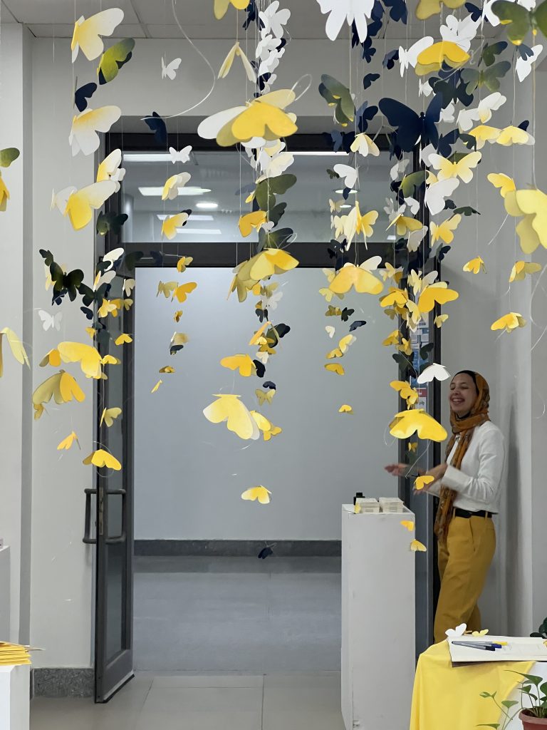Paper butterflies filling the exhibition corridor at the Holger Gladys memorial exhibition, Among Us