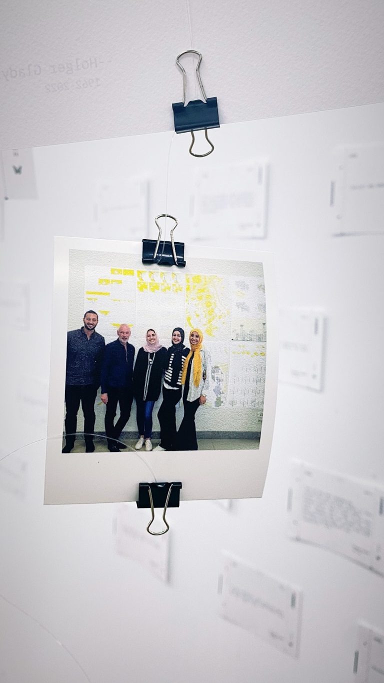 A photograph of a group of people clipped to the wall at the Holger Gladys memorial exhibition