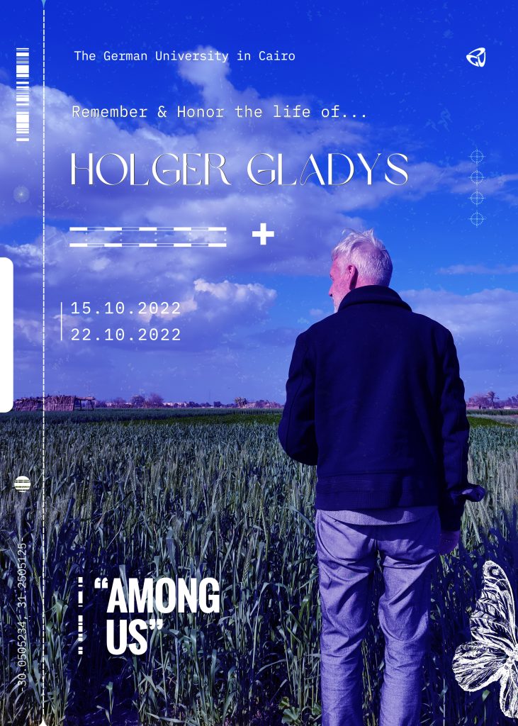 Entrance poster for the Holger Gladys Memorial Exhibition 'Among Us,' 15–22 October 2022 at the German University in Cairo, showing a man walking through a field, viewed from behind.