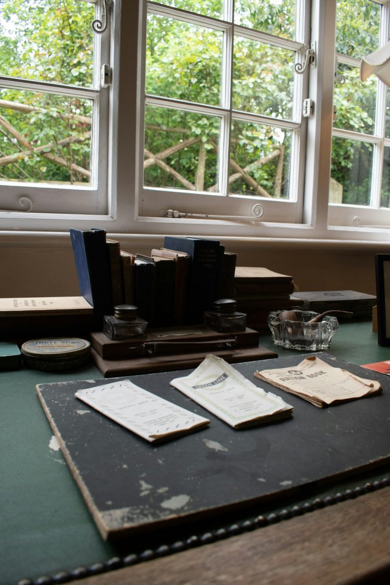 Vintage writing desk with inkwells, papers, and window view